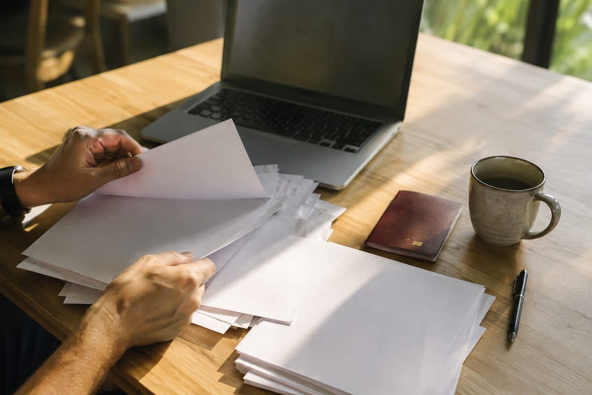 Table de travail avec un passeport, des documents administratifs et un ordinateur portable